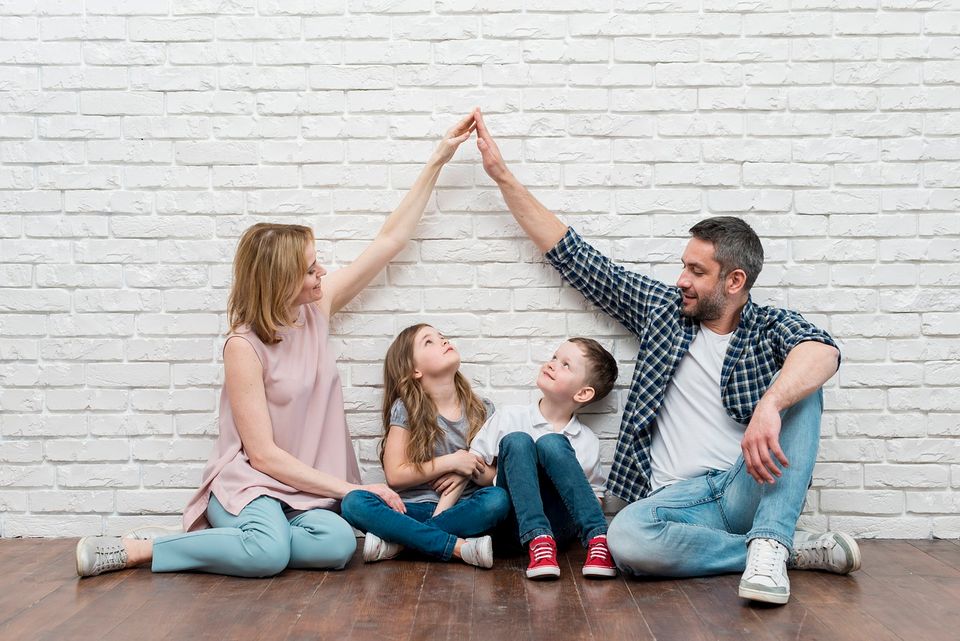 Imagen familiar de una madre y un padre con dos hijos (niño y niña) pequeños.